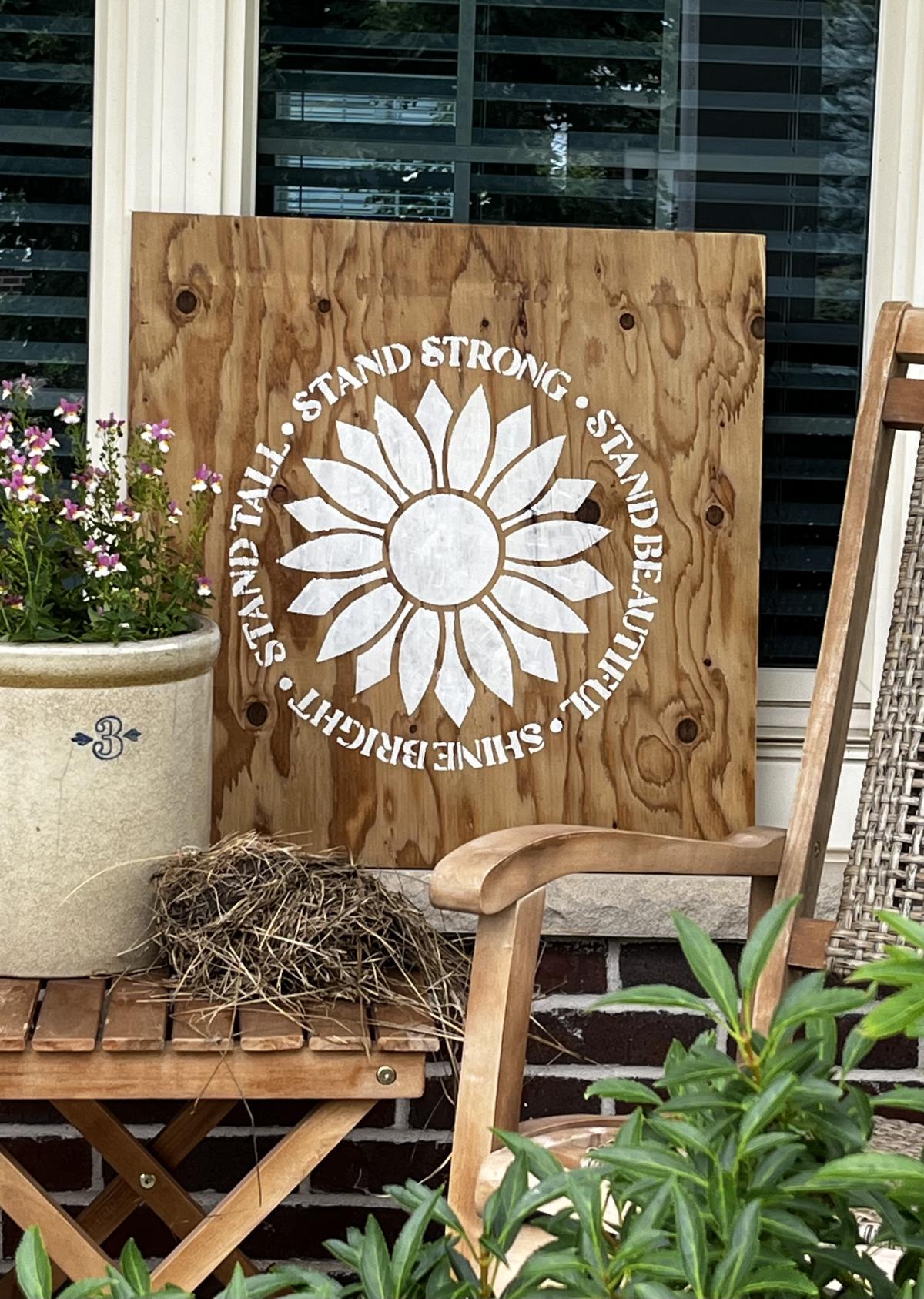 Wooden sign with sunflower stencil.