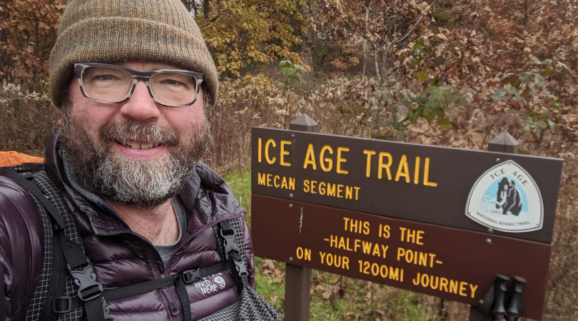 Photo of a man in front of a sign that says "Ice Age Trail"